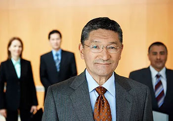 Key Person Insurance man in glasses and suit with people in background