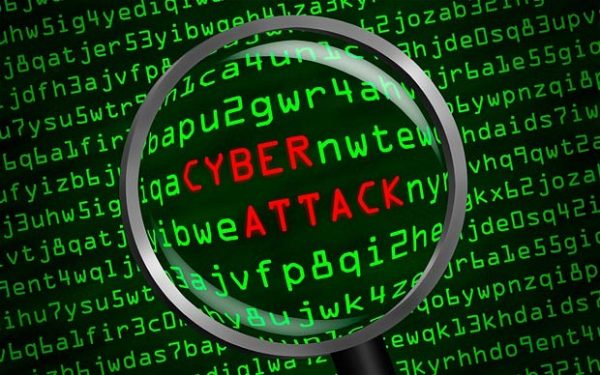 Cyber Liability magnify glass hovering over code on a computer with the words Cyber Attack in red